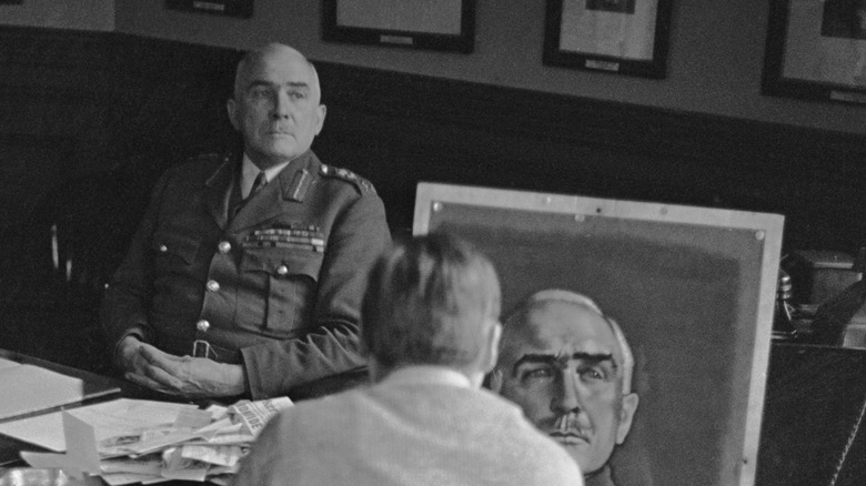 Edmund Ironside siting at his desk while a portrait artists paints him