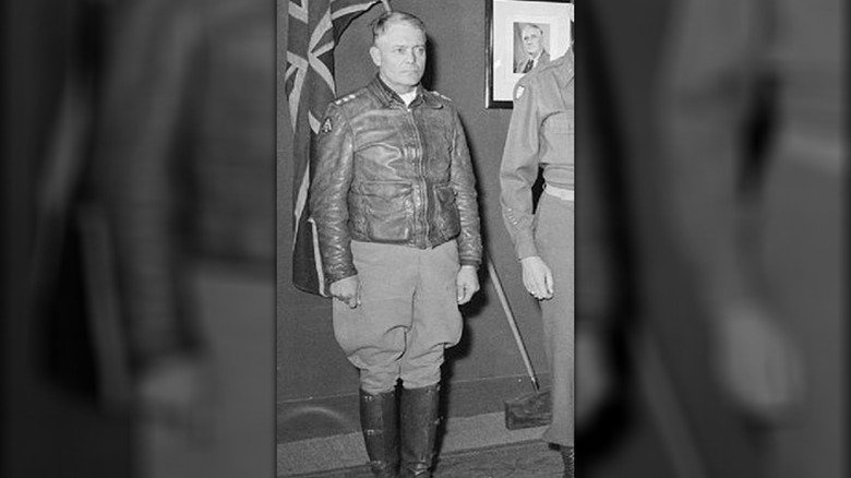 General Lucian Truscott standing by flag