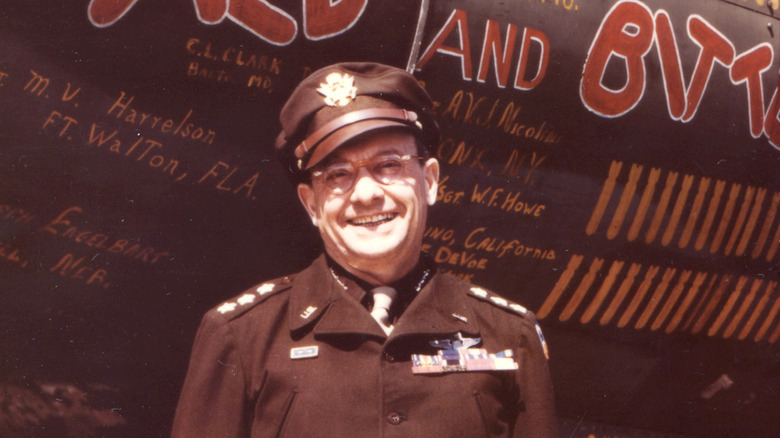 Lieutenant General Lewis Brereton smiling in front of plane named "Mild and Bitter"