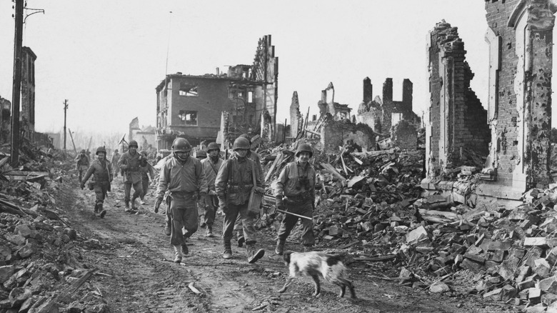 Major General Charles Gerhardt walking through a destroyed city with troops