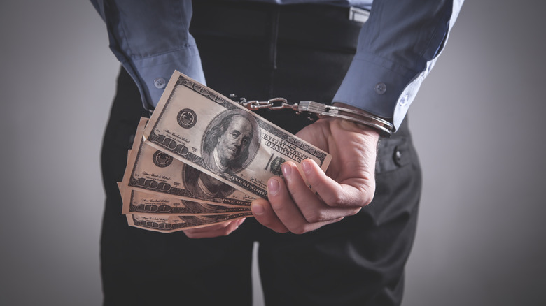 Man in handcuffs holding money