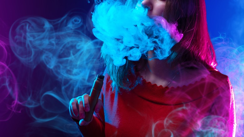 Girl blowing out vape smoke