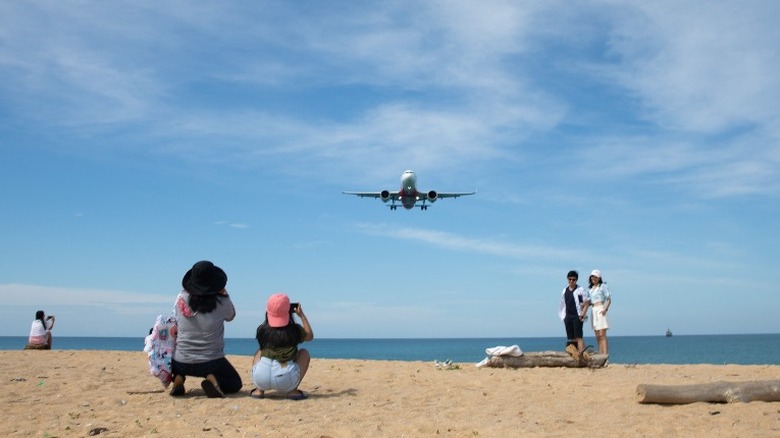 airplane flying over beach