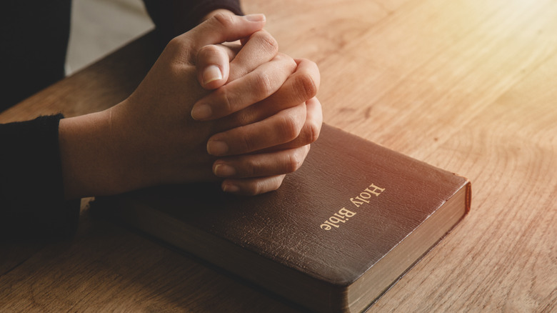 Hands folded on Bible