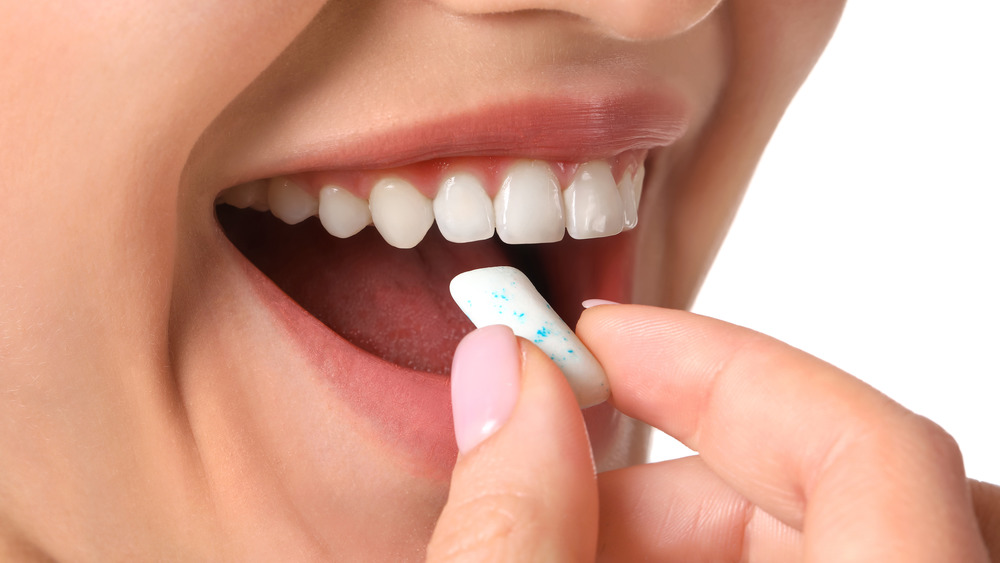 woman putting gum in mouth