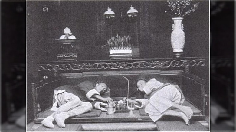 two men laying down and smoking