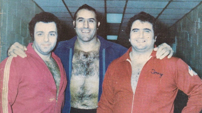 Gino Brito in a hallway with other wrestlers