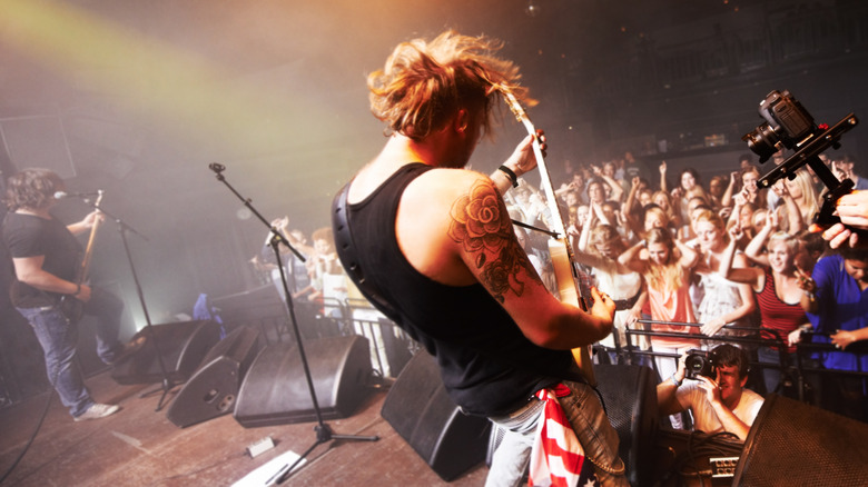 A band performing with on-stage wedge speakers