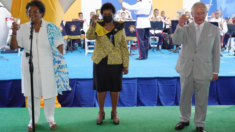 Prince Charles toasts with the prime minister and president of Barbados