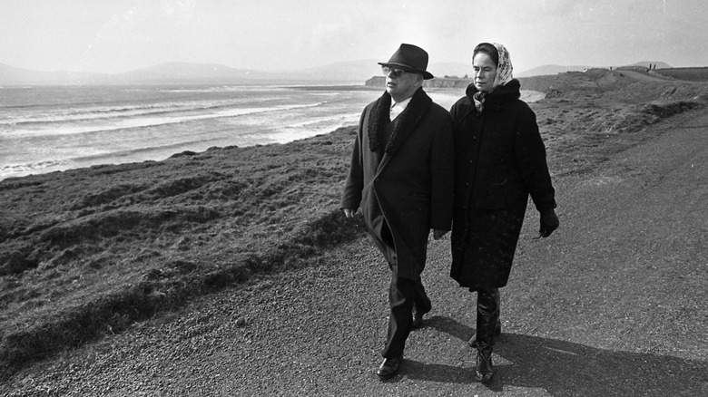Charlie Chaplin with woman walking by beach