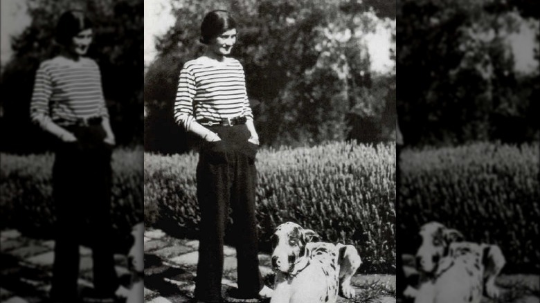 Коко Шанель стоит с собакой
