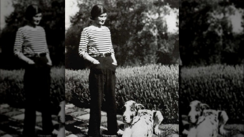 Coco Chanel standing with a dog