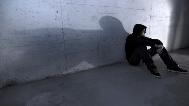 person sits against wall