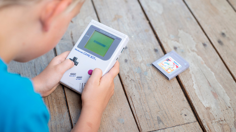 kid playing a nintendo gameboy
