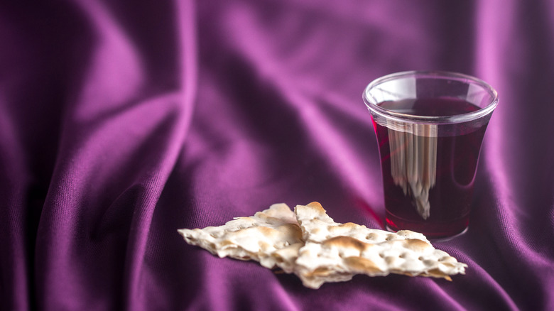 bread and wine on purple cloth