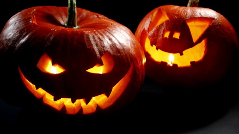 Two jack-o-lanterns glowing in the dark