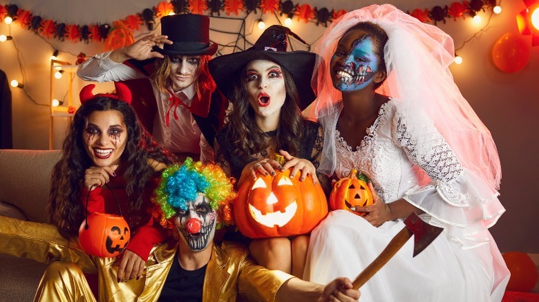 Four young adults in Halloween costumes
