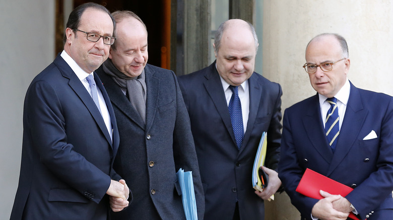 Francois Hollande shakes hands with cabinet members