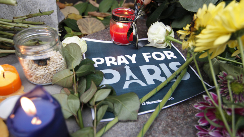 pray for paris sign with flowers and candles