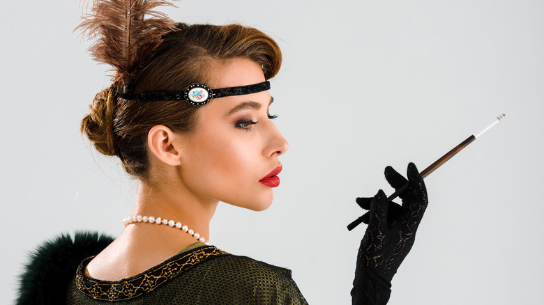 woman in costume holding cigarette holder