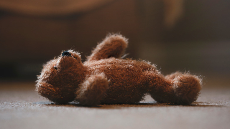 teddy bear lying alone on back