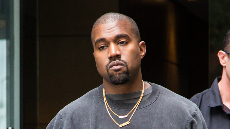Kanye West gold chains black shirt