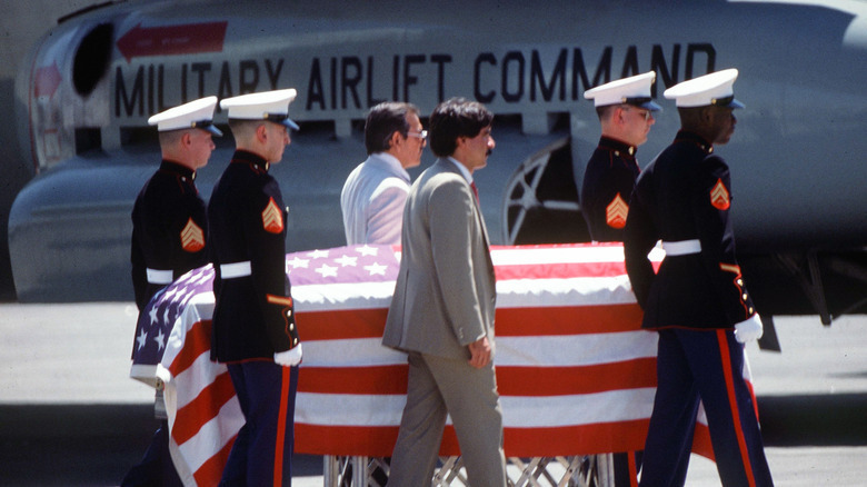 Casket flanked by military members carrying Enrique Camarena to airplane