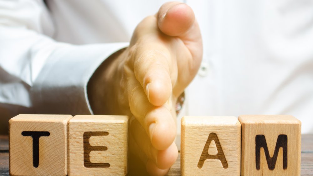 A hand -- a man's? -- splitting up a team