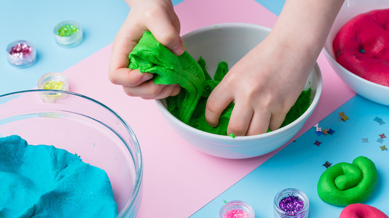 Children's hands playing with colorful clay