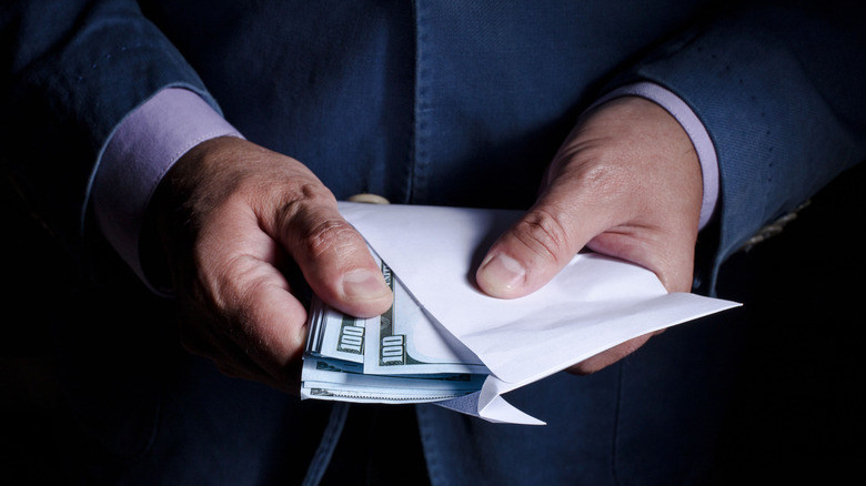Man pulling money out of envelope