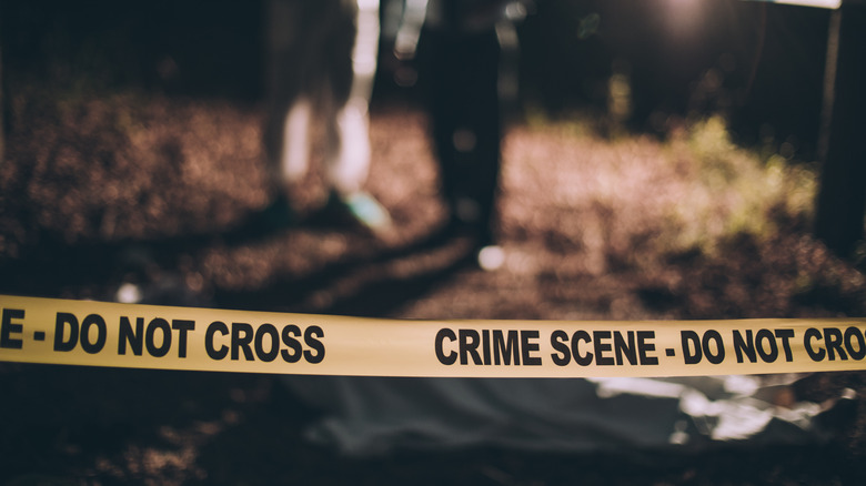crime scene tape with investigators 