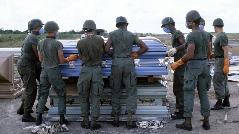 US military personnel stack coffins 