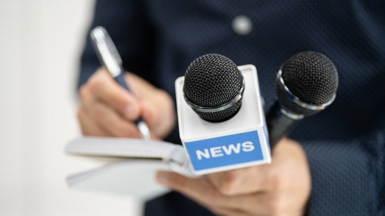reporter with microphones notepad