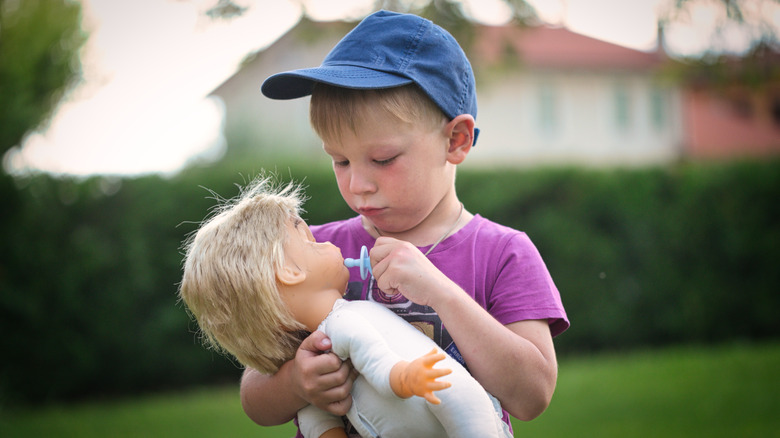 Little boy playing with a doll