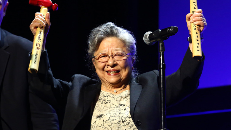Koko Kondo holding a hammer-shaped award at a film festival