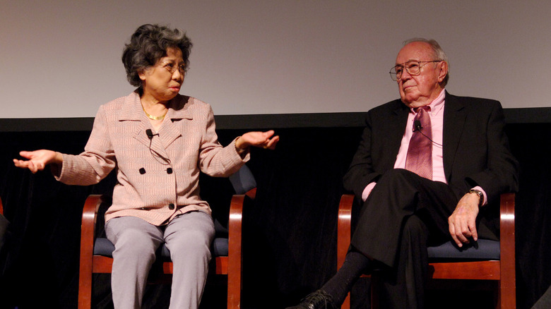 Shigeko Sasamori speaking on stage next to Theodore Van Kirk, navigator of the Enola Gay