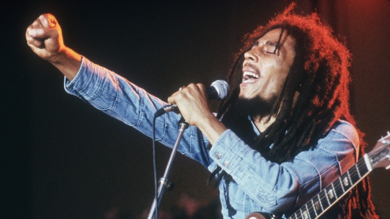 Bob Marley singing onstage with one fist raised