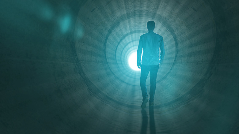 Man walks toward light in tunnel