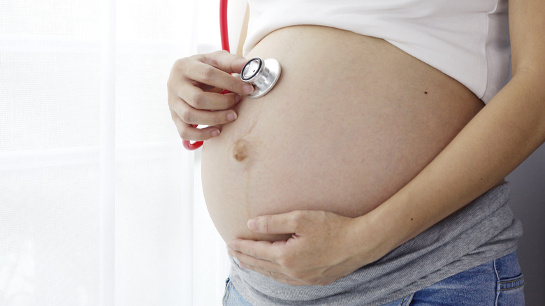 Pregnant woman with stethoscope on belly