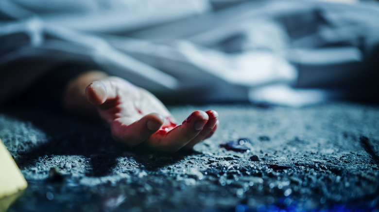 Homicide crime scene with close up of a human hand
