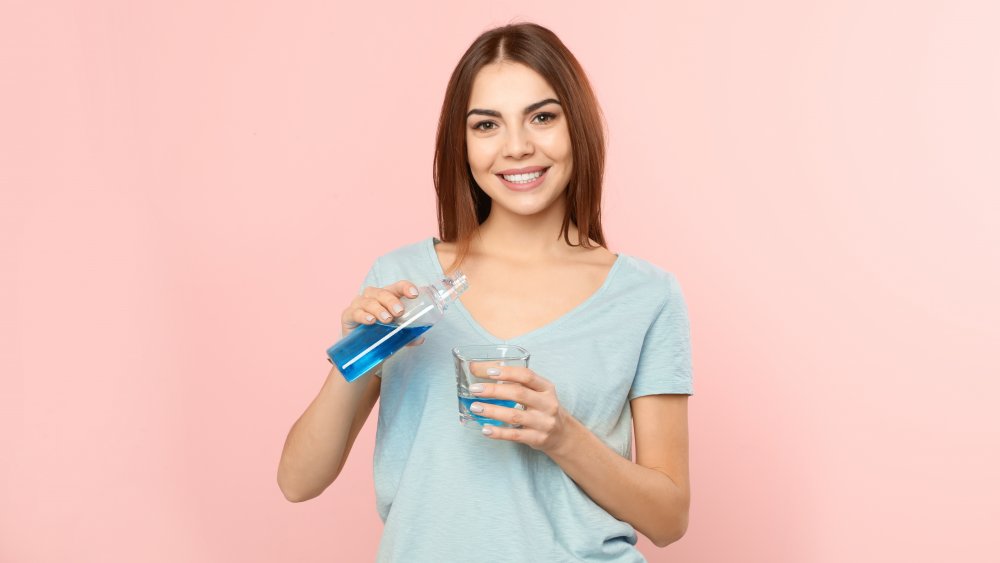 woman holding bottle of blue fluid