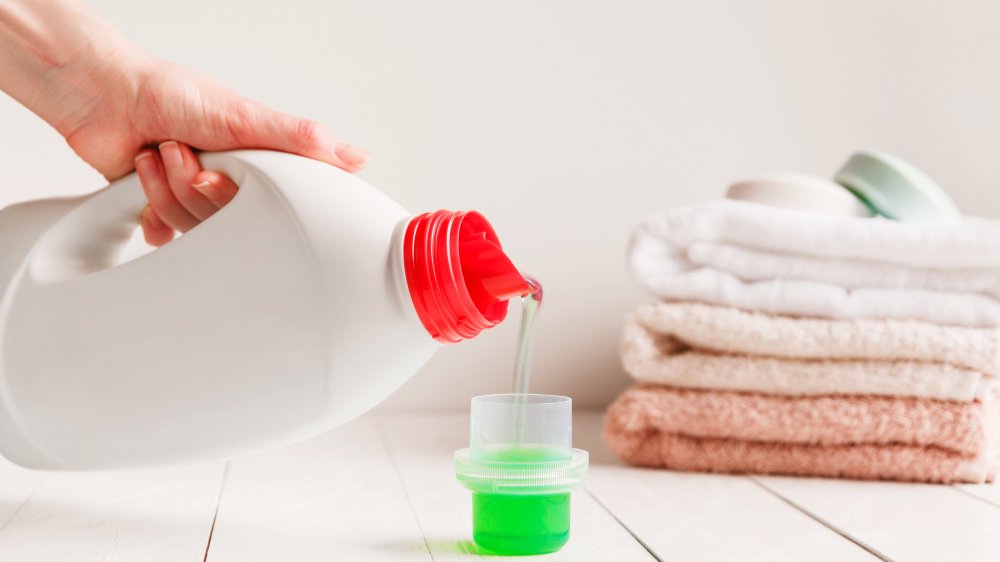 Hand pouring laundry detergent 