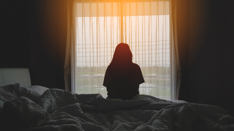 woman sitting on bed