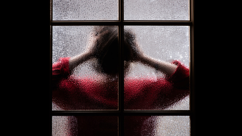 woman behind tempered glass window