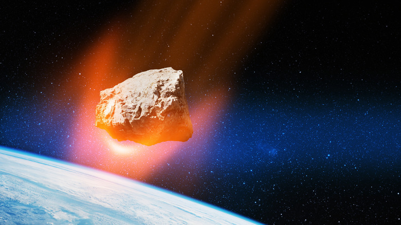 flaming ateroid in space above earth