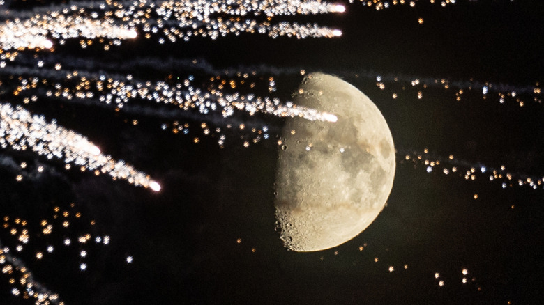 the moon hiding behind fireworks