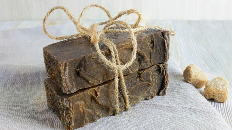 Handmade lye soap tied together with twine on top of a towel