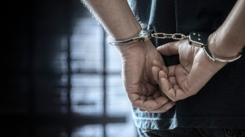 A man in dark clothes and handcuffs