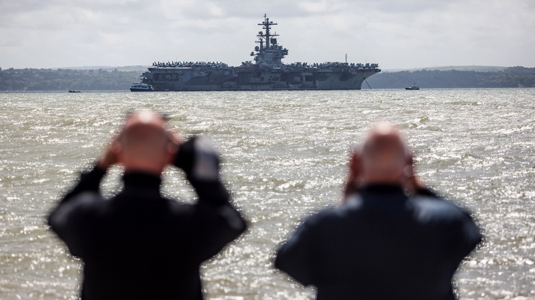 Sailors looking at ship with binoculars 