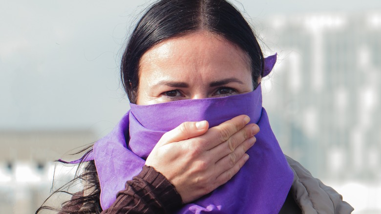 Woman with hand over her mouth 